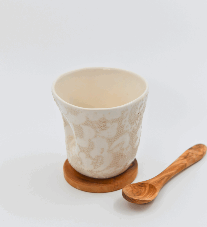 A textured ceramic mug, an olive wood spoon and a matching coaster